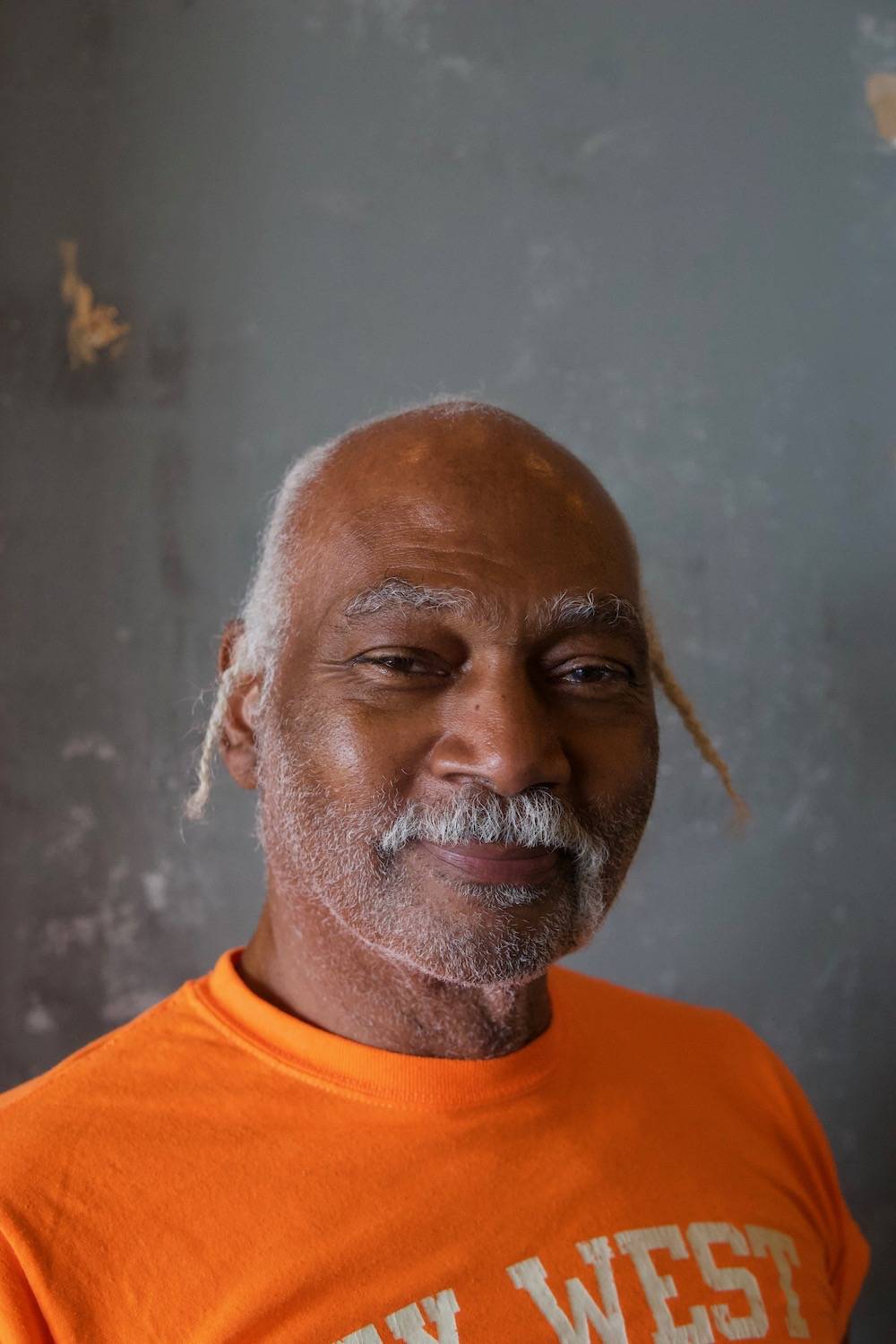 Close up portrait of Glenn Stewart. He's wearing an orange t-shirt.